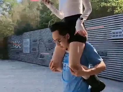 女孩骑在男孩脖子